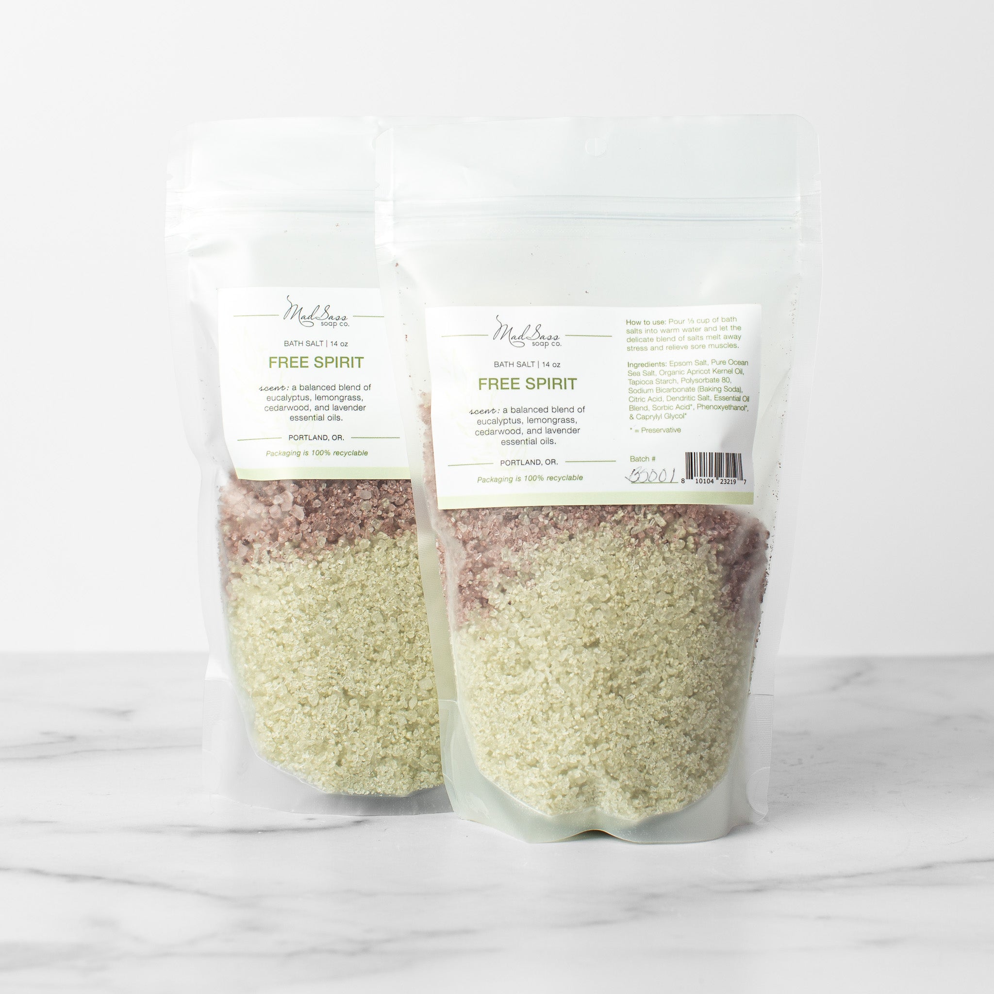 Two bags of Free Spirit bath salts on a white background. Free Spirit is a two toned layered bath salt in green and purple.