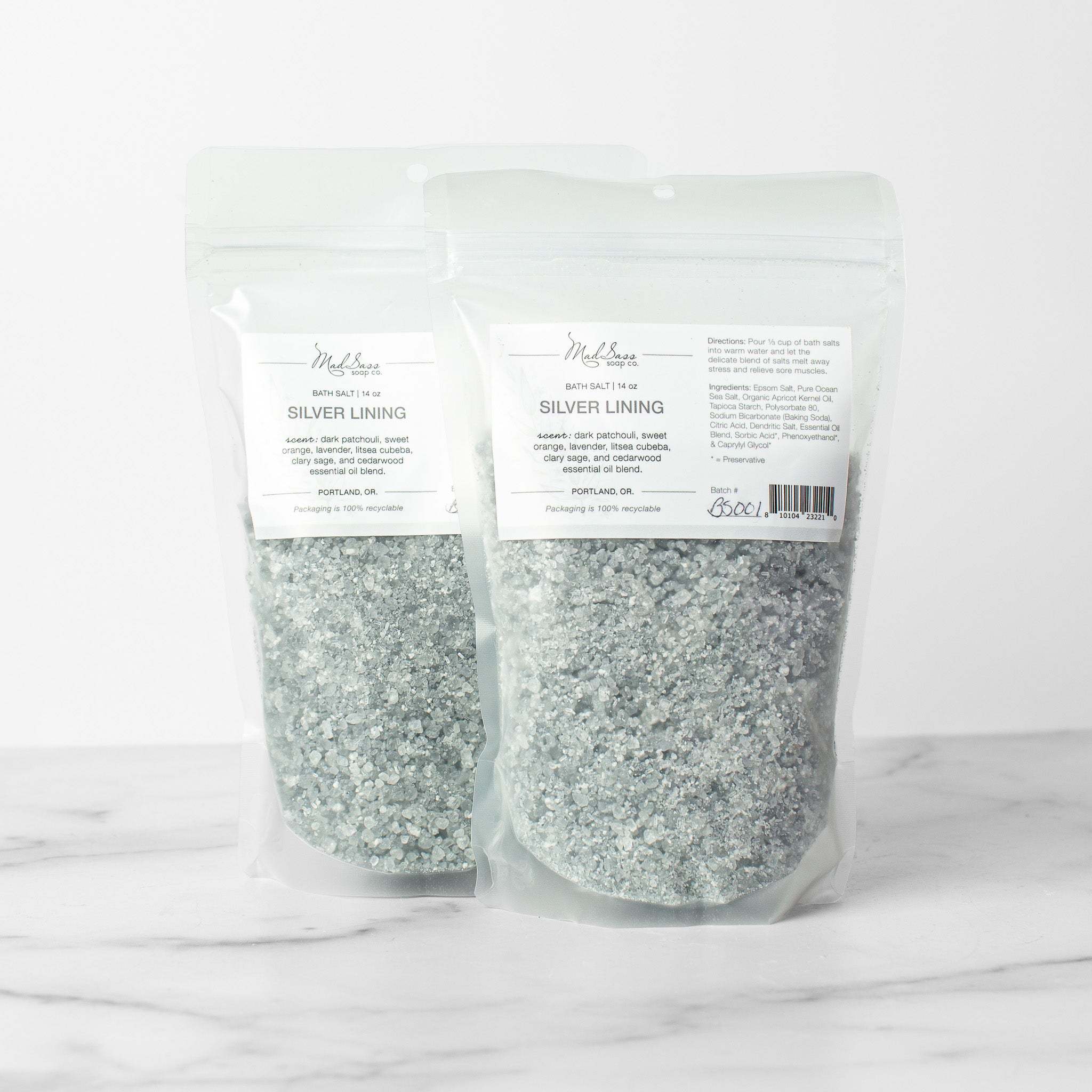 Two bags of Silver Lining bath salts on a white background. Silver Lining is a mixed grey and white bath salt.