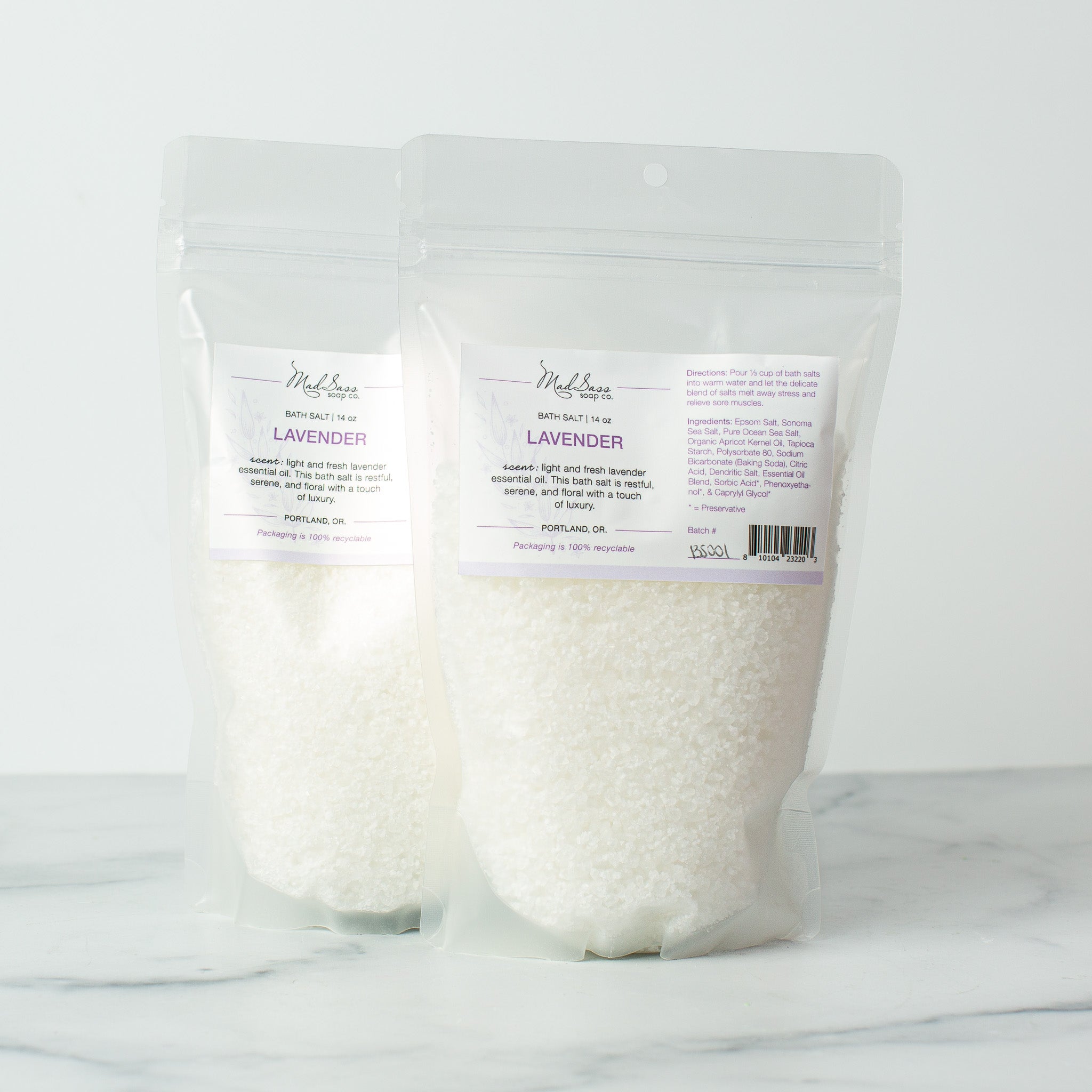 Two bags of Lavender bath salts on a white background. Lavender bath salts are pure white..