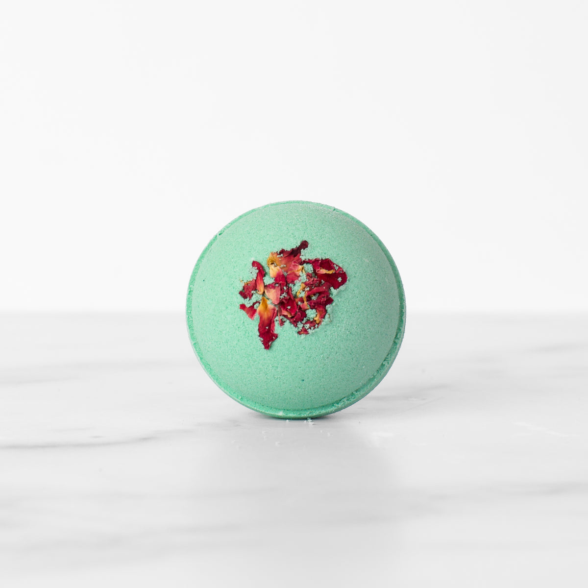 Single Fog & Rose hydrating luxury bath bomb by Mad Sass Soap Co, featuring a striking turquoise color adorned with floral details, perfect for creating a relaxing spa ambiance.