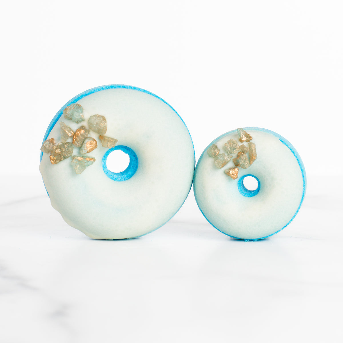 Luxury Sea Salt & Neroli bath bomb by Mad Sass Soap Co, showcasing a donut-shaped design with precious gemstones, embodying a hydrating luxury bath bomb experience.
