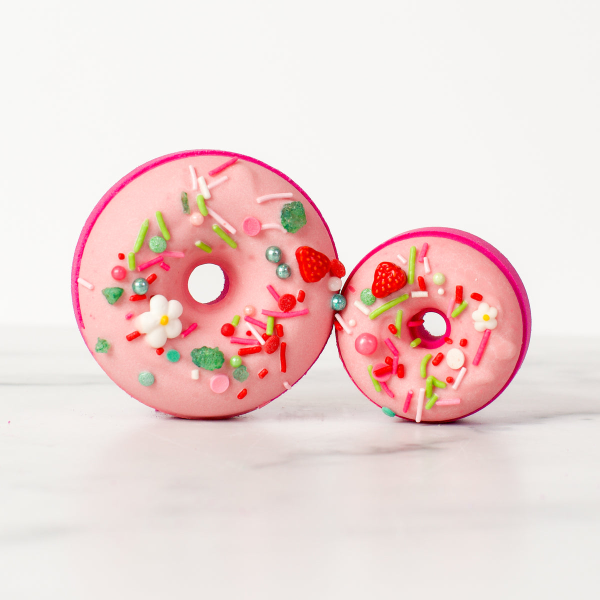 Luxurious Sonoma Strawberry - Bath Bomb by Mad Sass Soap Co, featuring a beautifully decorated pink donut shape, topped with colorful sprinkles, embodying the essence of a hydrating luxury bath bomb.