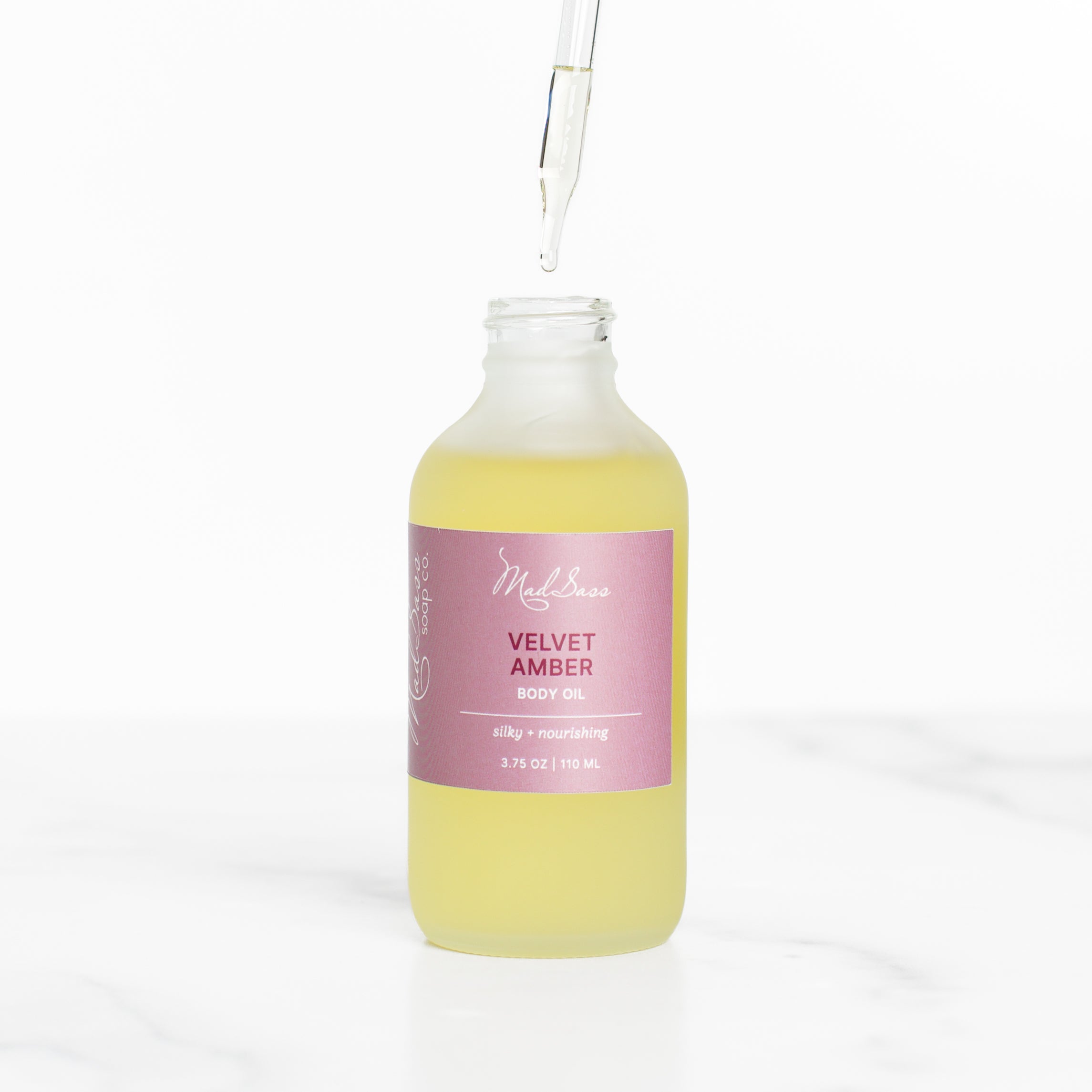 Close-up of Mad Sass Soap Co Velvet Amber - Body Oil with a dropper, emphasizing its rich, nourishing formula for ultimate skin hydration.
