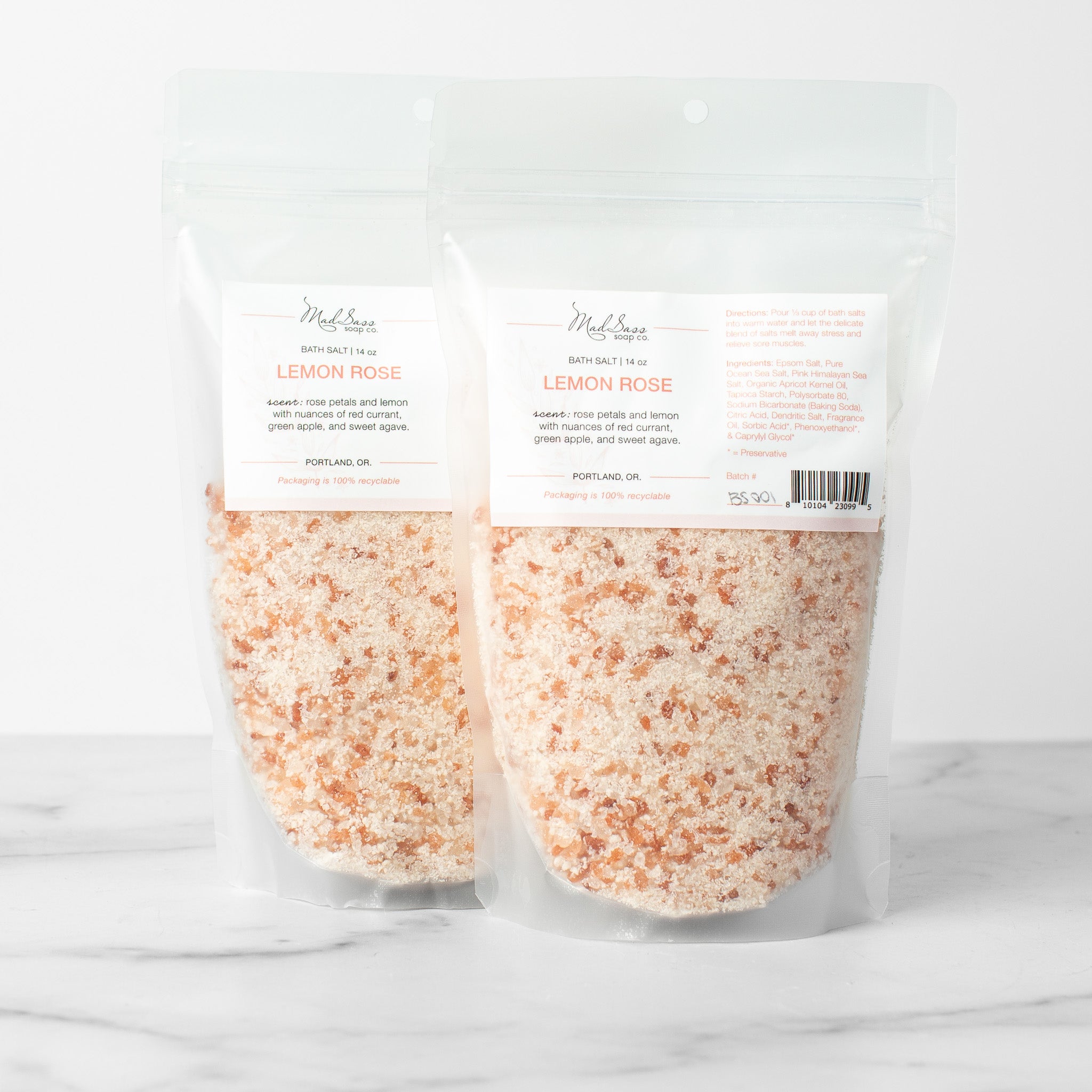 Two bags of Lemon Rose bath salts on a white background. Lemon Rose is a mixed pink and dark pink bath salt.