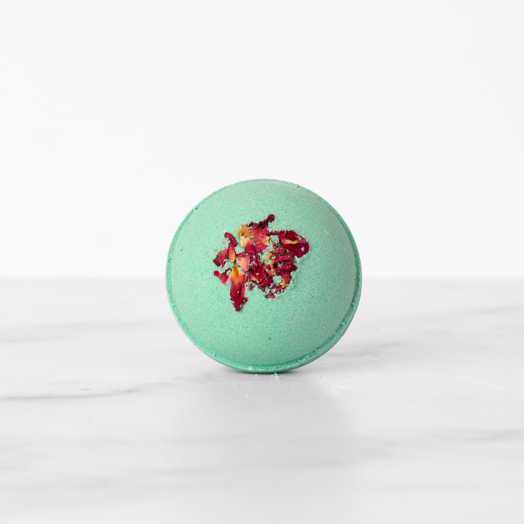 Single Fog & Rose hydrating luxury bath bomb by Mad Sass Soap Co, featuring a striking turquoise color adorned with floral details, perfect for creating a relaxing spa ambiance.