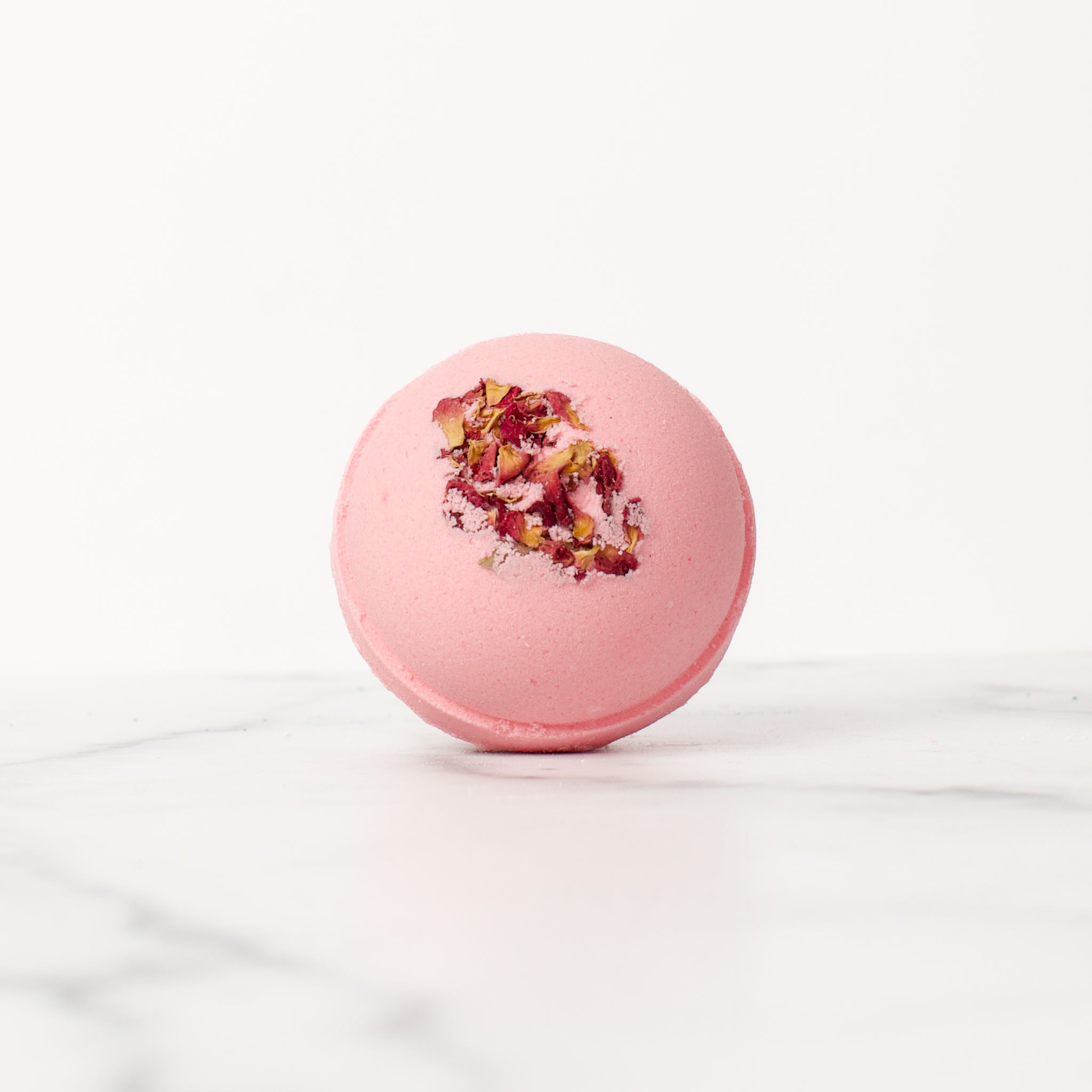 Single vibrant Lemon Rose bath bomb by Mad Sass Soap Co, featuring a beautiful pink hue adorned with rose petals, exemplifying the ultimate in hydrating luxury bath bomb experience.
