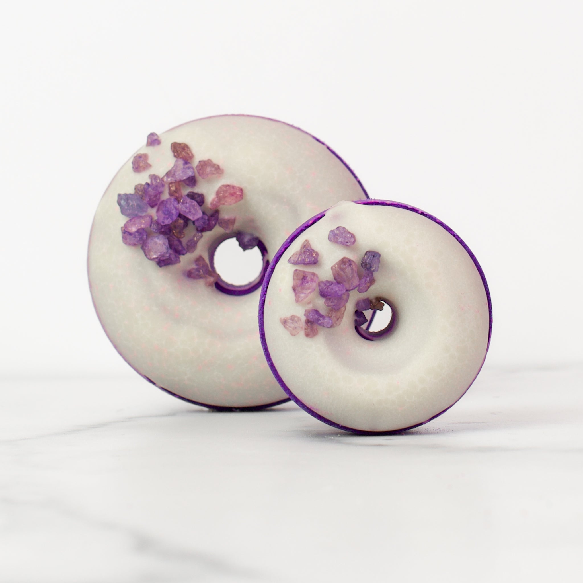 Stunning display of Moonflower bath bombs by Mad Sass Soap Co, including a large and mini donut bath bomb with purple crystals, perfect for a hydrating luxury bath bomb treatment.