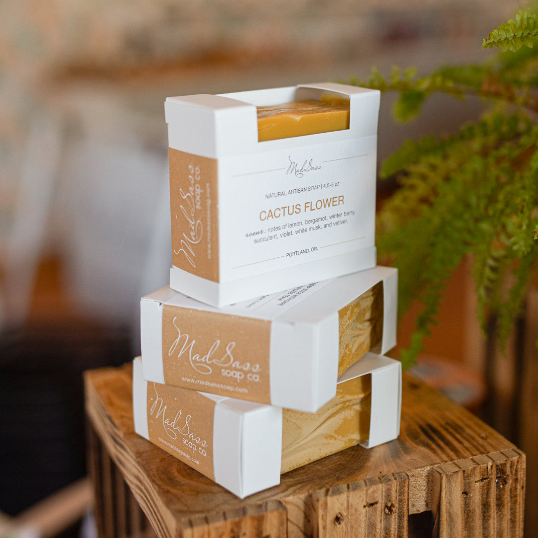 Three boxes of Cactus Flower soap stacked on top of each other on a wooden block.
