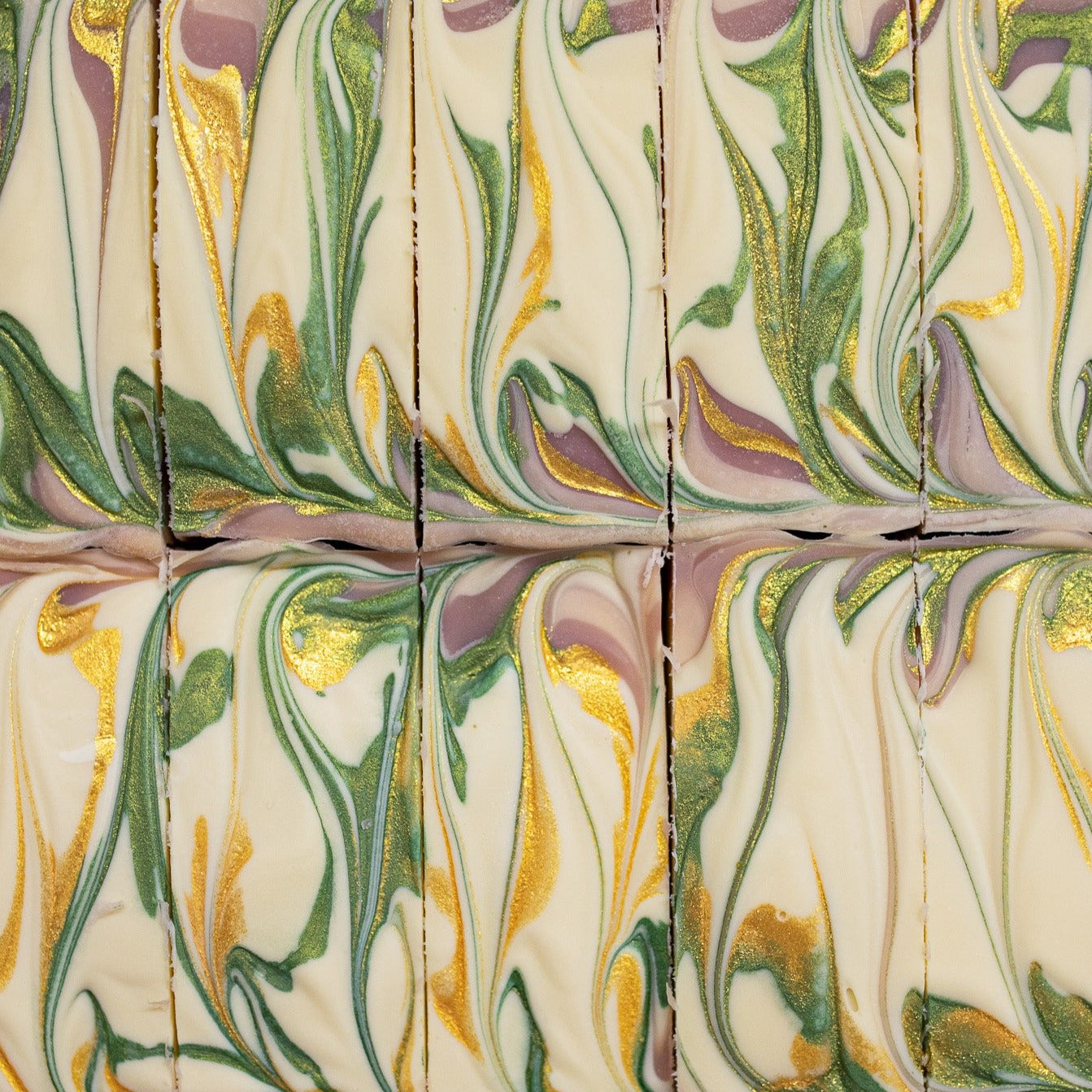 The purple, green, and gold swirl top of Fall Fig soap bars. 