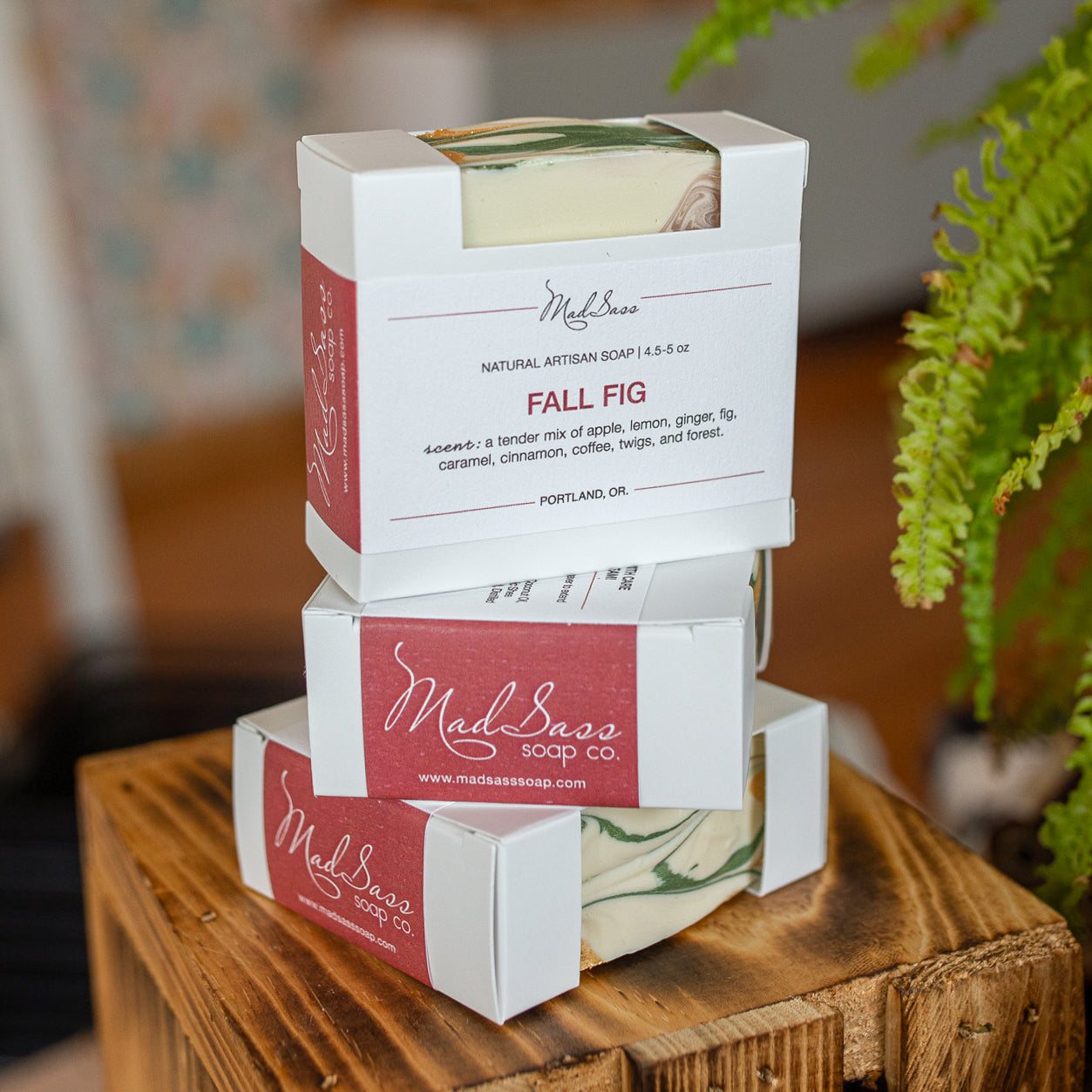 Three boxes of Fall Fig soap stacked on each other on a wooden block.