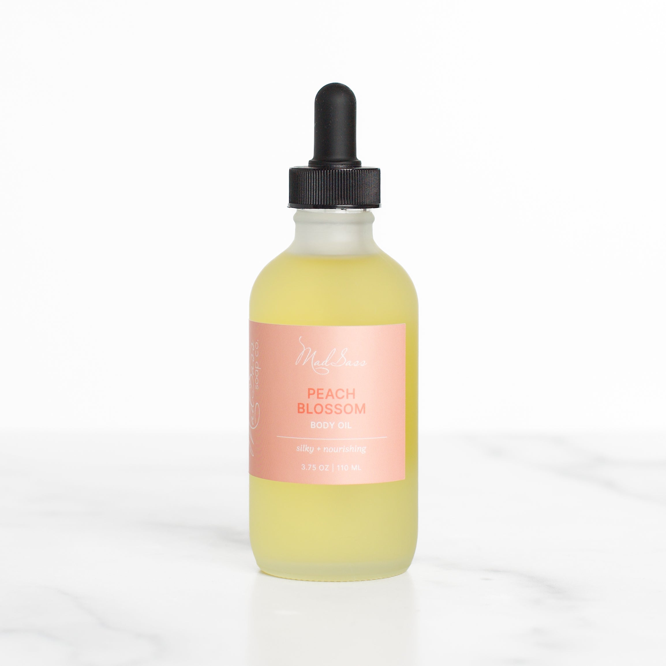 Elegant bottle of Peach Blossom skin nourishing body oil by Mad Sass Soap Co, showcasing a delicate dropper for precise application.